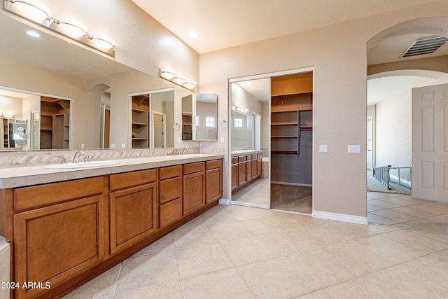 full bath featuring a sink, visible vents, double vanity, and tile patterned flooring