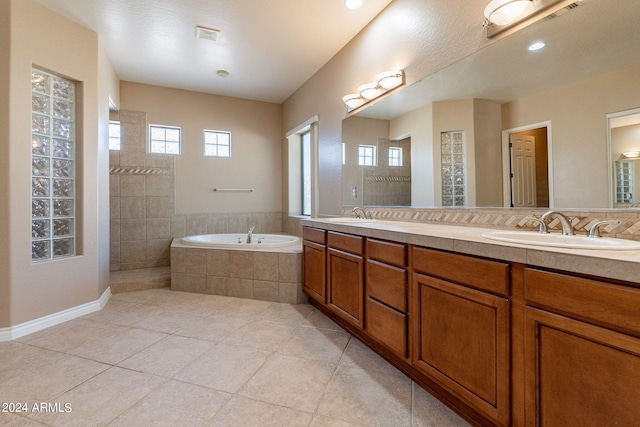 bathroom featuring tile patterned flooring, vanity, and shower with separate bathtub