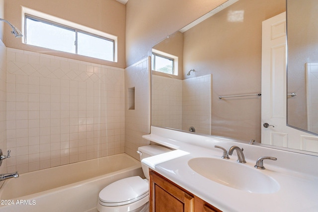 full bathroom featuring tiled shower / bath combo, vanity, and toilet