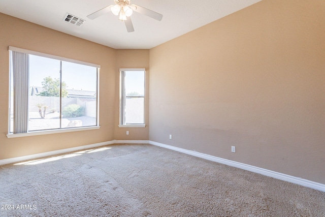 carpeted spare room featuring ceiling fan