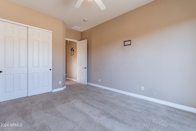 unfurnished bedroom featuring a closet, carpet floors, baseboards, and a ceiling fan