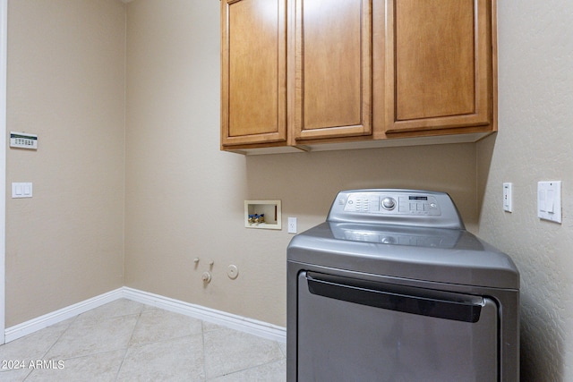 laundry area with tile patterned floors, washer / clothes dryer, cabinet space, and baseboards