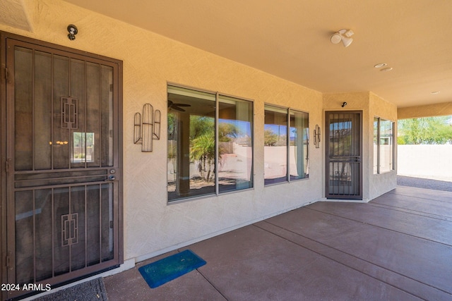 view of exterior entry with a patio area and stucco siding