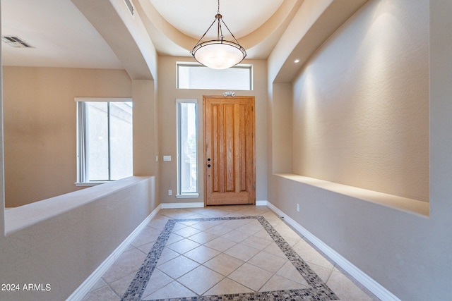 foyer entrance with visible vents, baseboards, and arched walkways