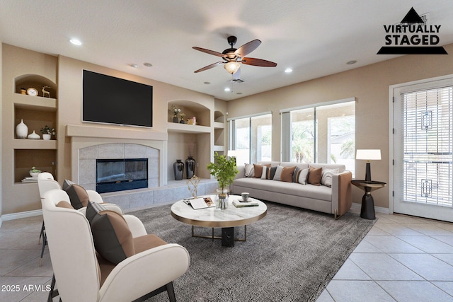 living room with light tile patterned floors, a healthy amount of sunlight, built in shelves, and baseboards