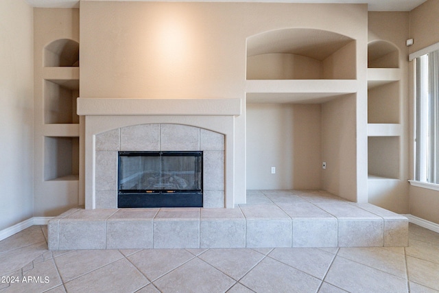 interior details with a fireplace, built in shelves, and tile patterned floors