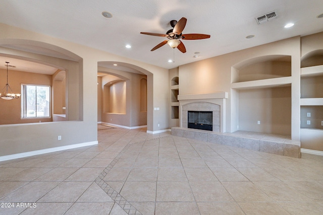 unfurnished living room with visible vents, built in features, a fireplace, light tile patterned floors, and baseboards