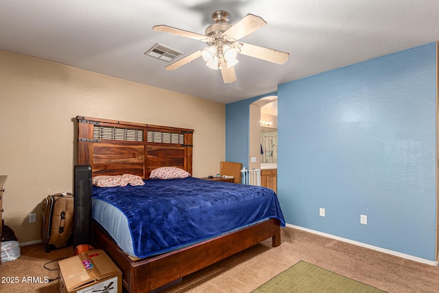 carpeted bedroom featuring ceiling fan and ensuite bath