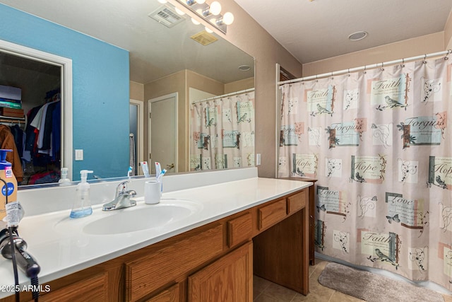 bathroom with tile patterned floors, walk in shower, and vanity