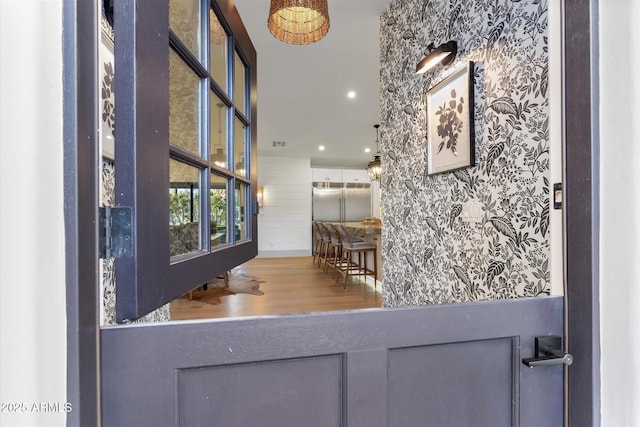 interior space featuring wood-type flooring and stainless steel built in fridge