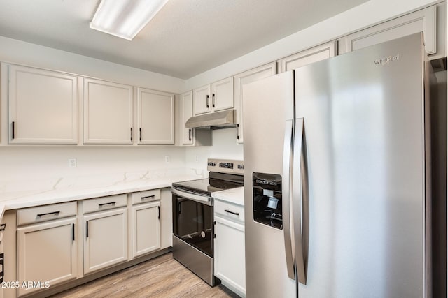 kitchen featuring light wood-style floors, light stone counters, stainless steel appliances, under cabinet range hood, and white cabinetry