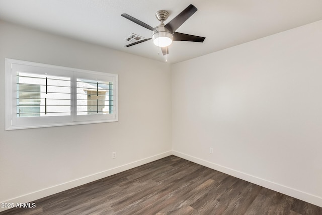 spare room with a ceiling fan, dark wood-style flooring, visible vents, and baseboards