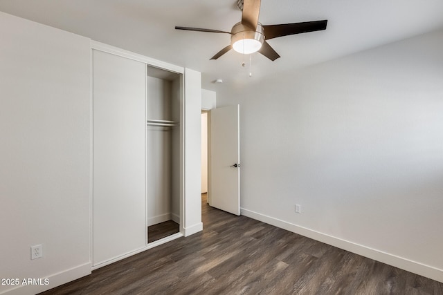 unfurnished bedroom with ceiling fan, a closet, dark wood finished floors, and baseboards