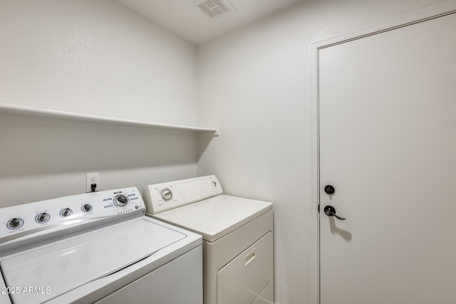 washroom featuring laundry area, visible vents, and washer and clothes dryer