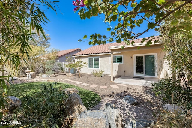 rear view of house with a patio, stucco siding, central AC, fence, and a tiled roof