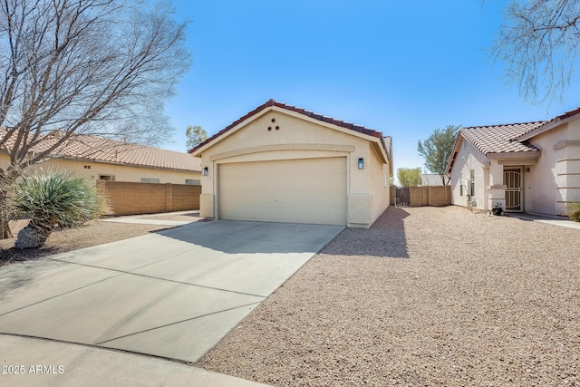 view of front of property with a garage, a tile roof, an outbuilding, fence, and stucco siding