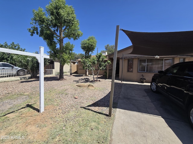 view of yard with fence and a carport