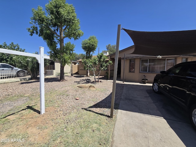 view of yard featuring fence and an attached carport