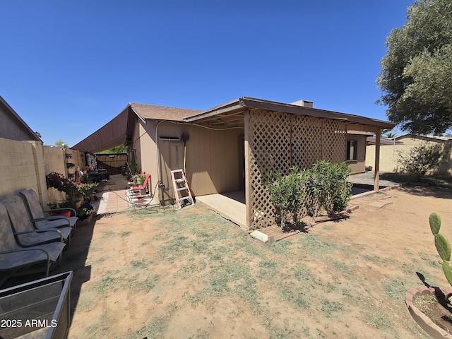 rear view of property featuring a patio and a fenced backyard