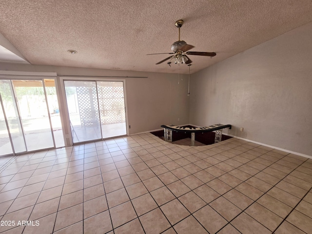 spare room featuring baseboards, a ceiling fan, a textured ceiling, and light tile patterned floors
