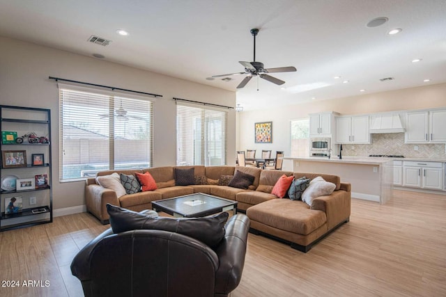 living room with light hardwood / wood-style floors, plenty of natural light, and ceiling fan