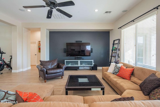 living room with wood-type flooring, a wealth of natural light, and ceiling fan