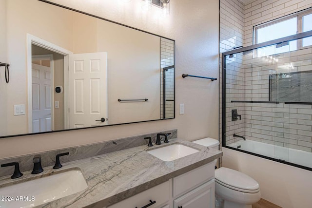 full bathroom with vanity, toilet, and combined bath / shower with glass door