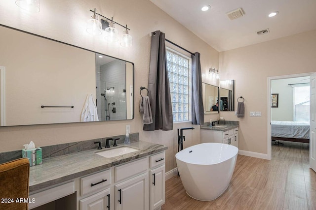 bathroom featuring separate shower and tub, hardwood / wood-style floors, and vanity