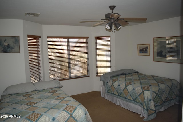 carpeted bedroom with multiple windows and ceiling fan