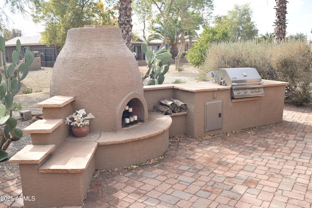 view of patio / terrace featuring area for grilling, a grill, and an outdoor fireplace