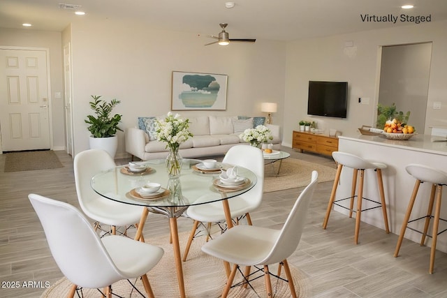 dining area with light hardwood / wood-style flooring and ceiling fan