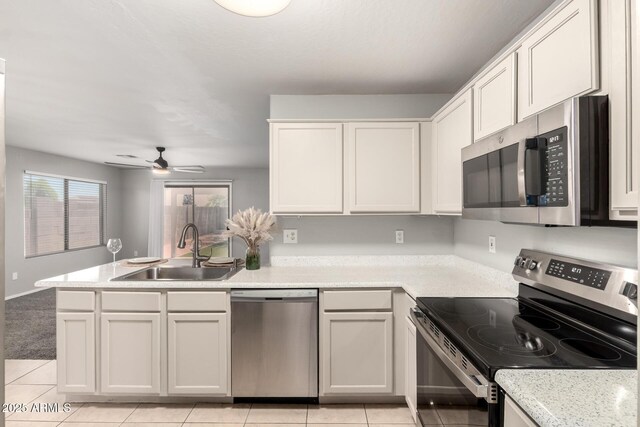 14919 W Hearn Cir, Surprise, AZ 85379 - kitchen featuring appliances with stainless steel finishes, a sink, a peninsula, light countertops, and light tile patterned flooring