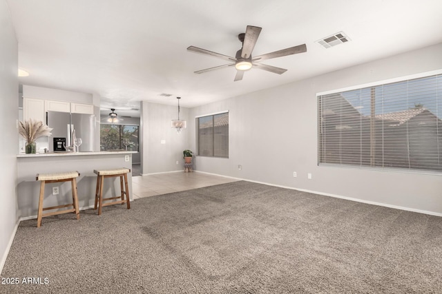 14919 W Hearn Cir, Surprise, AZ 85379 - unfurnished living room with ceiling fan, light carpet, and baseboards