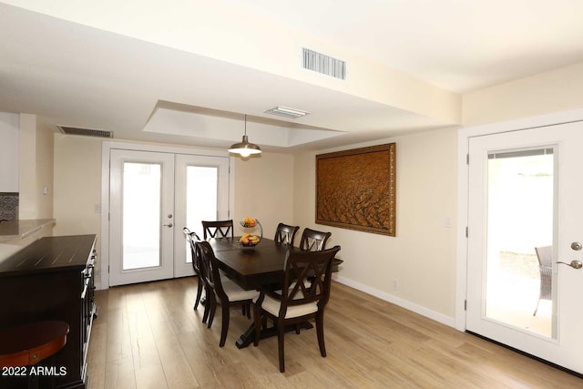 dining space with light hardwood / wood-style flooring and french doors