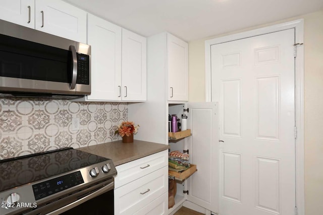 kitchen featuring white cabinets, decorative backsplash, and stainless steel appliances