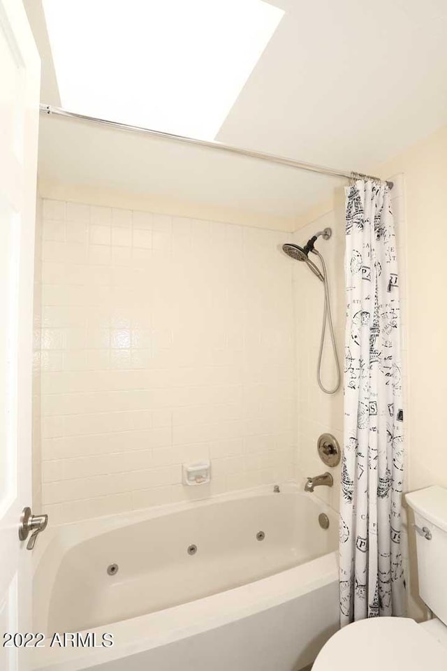 bathroom featuring toilet and shower / bath combo with shower curtain