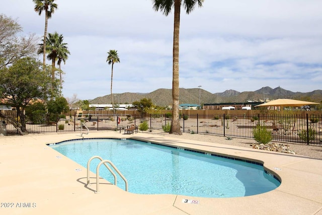 view of swimming pool with a patio area and a mountain view