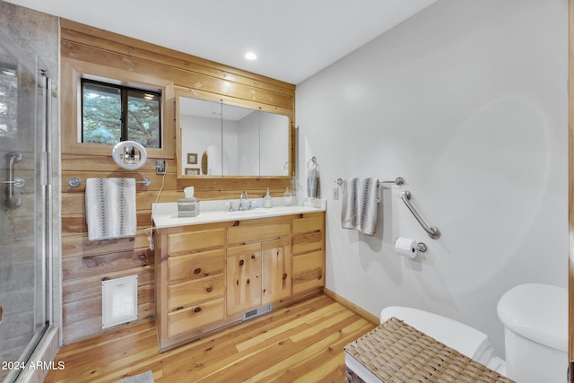 bathroom featuring vanity, toilet, wood-type flooring, and an enclosed shower