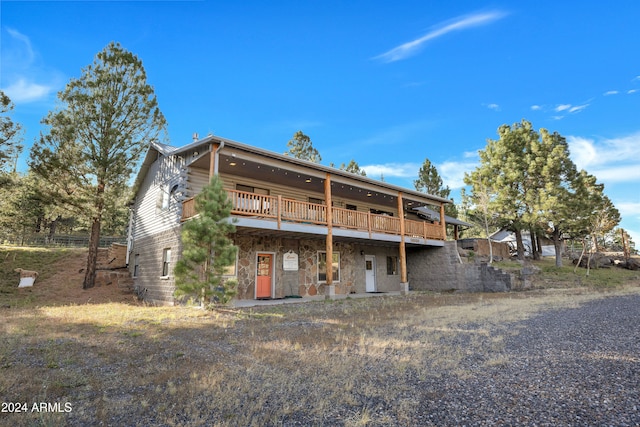 rear view of house featuring a wooden deck