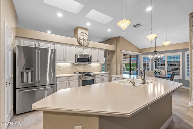 kitchen featuring appliances with stainless steel finishes, a large island, sink, and decorative backsplash