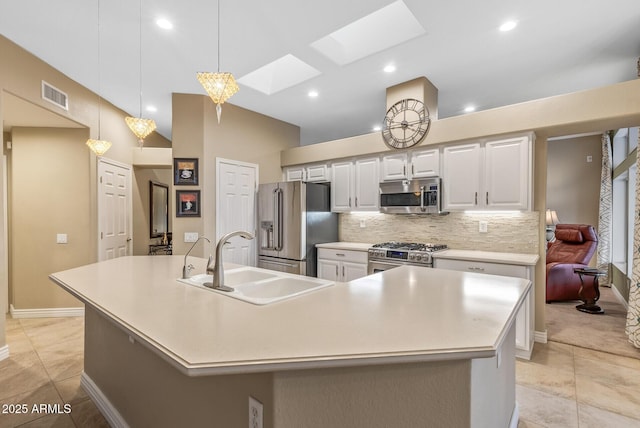 kitchen with a spacious island, sink, a skylight, pendant lighting, and stainless steel appliances