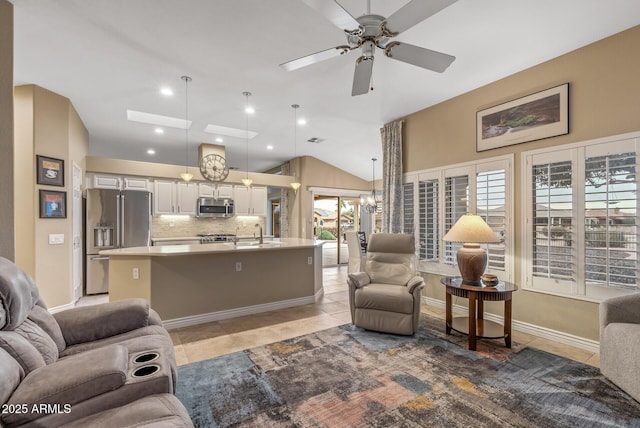 tiled living room featuring lofted ceiling, ceiling fan, and a healthy amount of sunlight