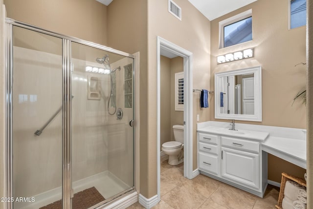 bathroom featuring tile patterned flooring, vanity, an enclosed shower, and toilet