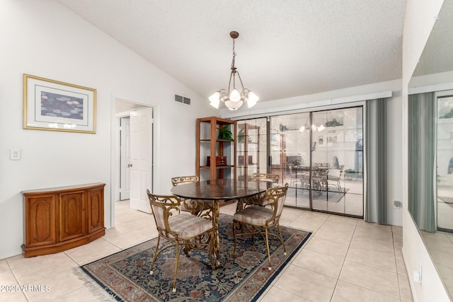 dining area featuring vaulted ceiling, an inviting chandelier, light tile patterned floors, and a textured ceiling