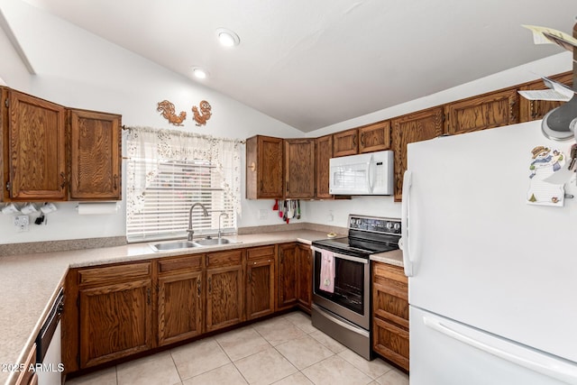 kitchen with vaulted ceiling, light tile patterned floors, appliances with stainless steel finishes, and sink