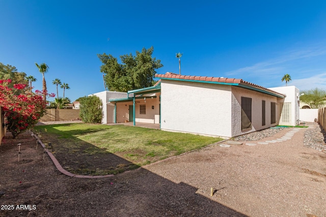 rear view of property with a yard and a patio