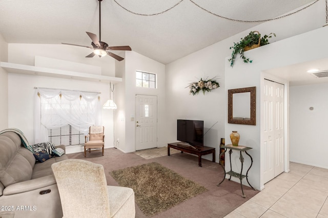 living room featuring ceiling fan, light tile patterned floors, and vaulted ceiling