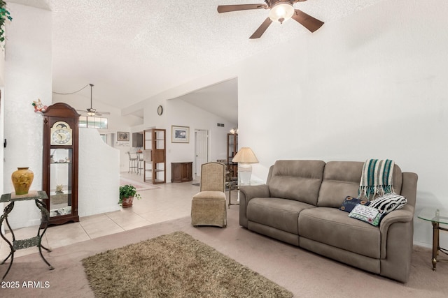 tiled living room featuring ceiling fan, vaulted ceiling, and a textured ceiling