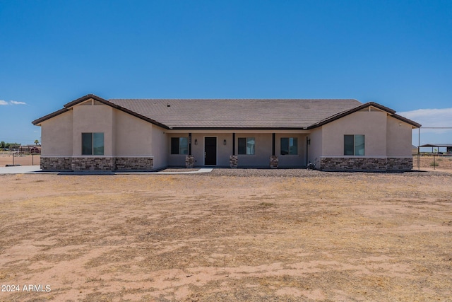 view of front of property featuring stone siding, a tile roof, and stucco siding