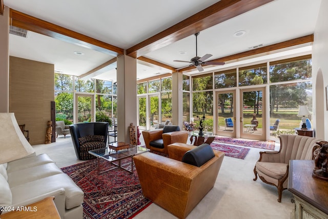 sunroom with ceiling fan and beam ceiling